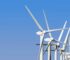 Wind turbines generating clean energy stand tall against a clear blue sky, highlighting sustainable technology.