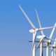 Wind turbines generating clean energy stand tall against a clear blue sky, highlighting sustainable technology.