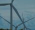 Wind turbines in a lush landscape under blue skies, symbolizing sustainable energy.